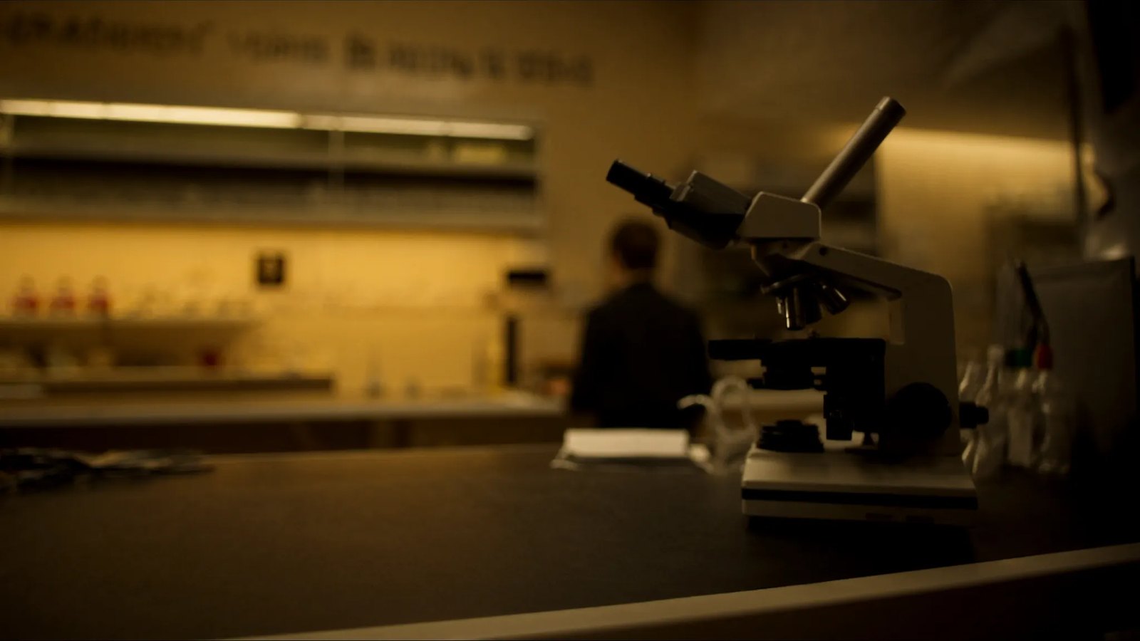 a photograph, 16:10: a dark laboratory with one instrument lit